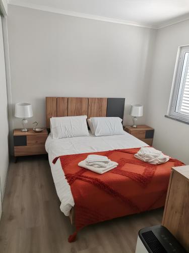 a bedroom with a bed with two towels on it at Casa do Carapacho in Luz