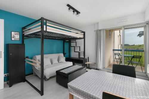 a room with a bed and a table and a dining room at Studio Emma in Le Croisic
