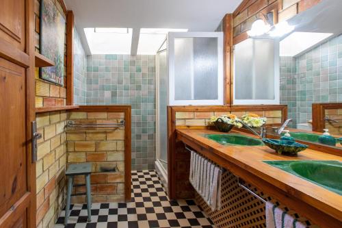a bathroom with two sinks and a checkered floor at Ca'n Pont in El Port
