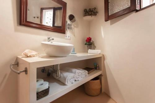 a bathroom with a sink on a shelf with towels at Can Garí in Sóller