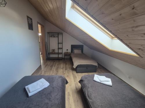 a attic bedroom with two beds and a skylight at Apartamenty pod Orzechem in Kościerzyna