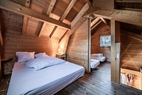a bedroom with a bed in a wooden cabin at Chalet 6p Classique - Les Biches in Verchaix