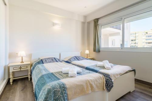 two twin beds in a bedroom with a window at Apartment Acapulco 6 in Fuengirola