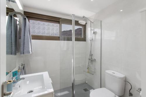 a white bathroom with a toilet and a sink at Eucalipto-Sun guaranteed-pool wifi in Puerto Rico de Gran Canaria