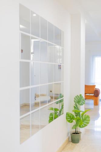 a mirror in a white room with a plant at Villa Vetrano in Cimitile