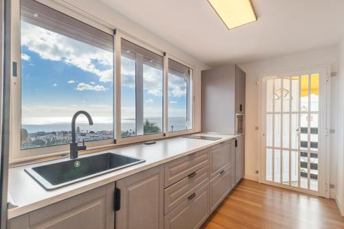 a kitchen with a sink and large windows at Monterojo San Agustin Las Burras in San Agustin