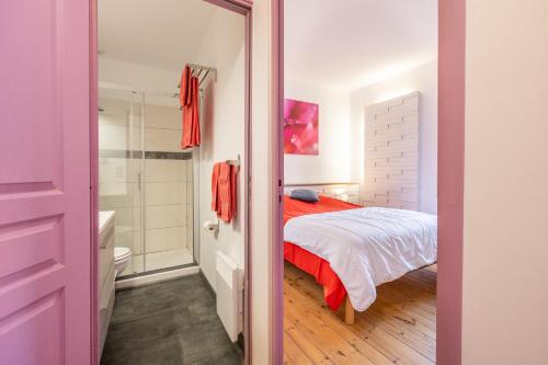 a bedroom with a bed and a bathroom with a shower at Chambres D'hôtes Le Palmier in Sevremont
