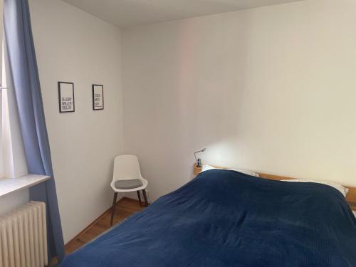 a bedroom with a blue bed and a chair at Apartment im Scheffelhaus in Gengenbach