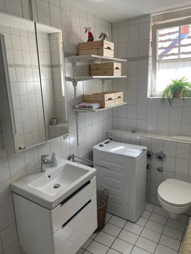 a white bathroom with a sink and a toilet at Apartment im Scheffelhaus in Gengenbach