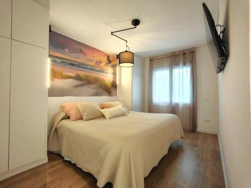 a bedroom with a bed with a painting on the wall at Primera linea Sant Antoni Calonge in Sant Antoni de Calonge