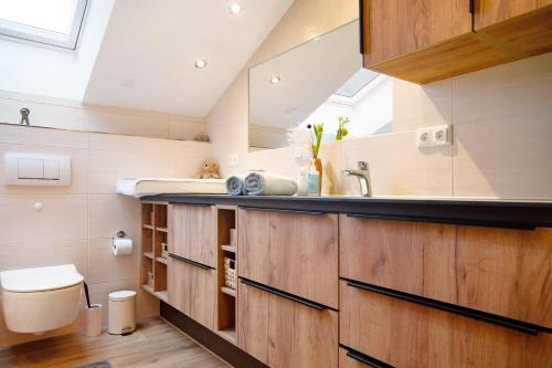 a bathroom with wooden cabinets and a sink at Ferienwohnung Caprano in Sonthofen