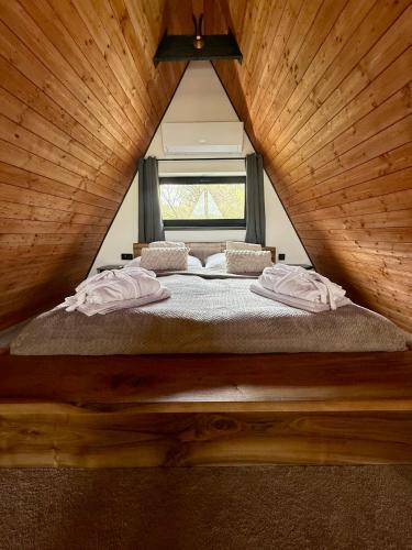 a bed in a wooden room with a window at Chalet Tri pramene in Moravské Lieskové