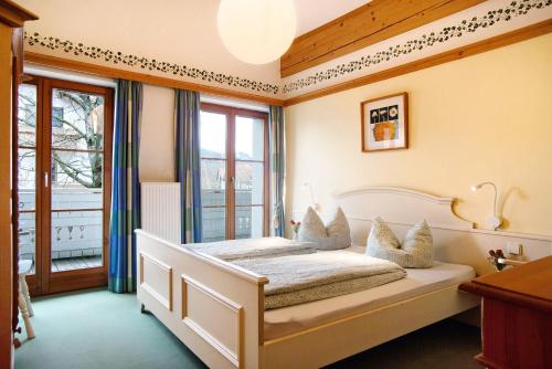 a bedroom with a white bed with a window at Ferienwohnung Caprano in Sonthofen