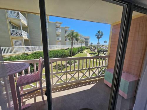 a balcony with a table and a chair and a view at Ocean & Pool View - Hot Tubs - 2 Pools - Gym - Tennis ct - on seawall - Shoreline Stays 08 in Galveston