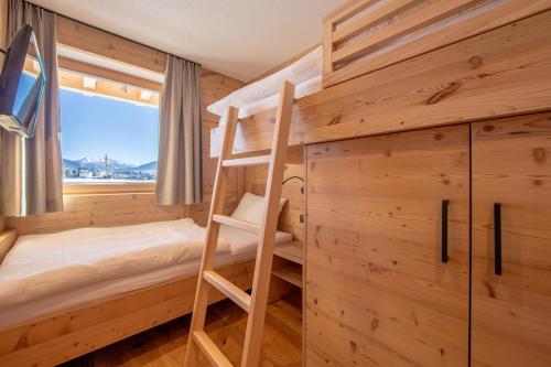 a bedroom with bunk beds and a tv in a cabin at Metzgermayr in Villabassa