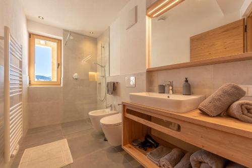 a bathroom with a sink and a toilet and a shower at Metzgermayr in Villabassa