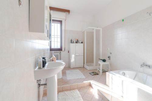 a white bathroom with a sink and a tub at Casa Belvedere in Foiano della Chiana