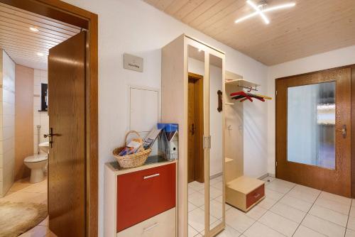 a bathroom with a toilet and a door with a mirror at Ferienwohnung Eleonore in Meßstetten