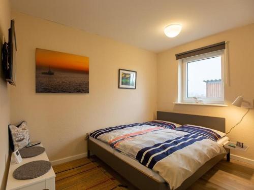 a bedroom with a bed and a window at Fewo Op de Warft in Pellworm