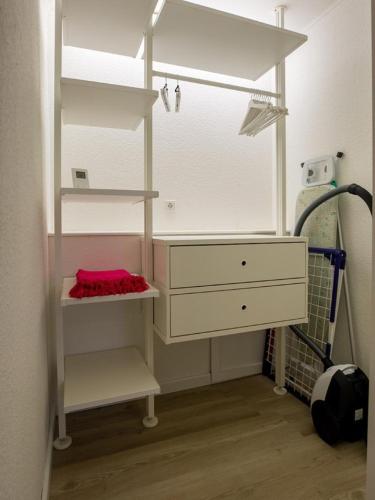 a closet with a white dresser and a shelf at Fewo Op de Warft in Pellworm