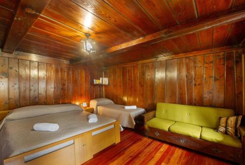 a room with two beds and a couch in a wooden room at Luéisch Ketschu near Gressoney in Issime