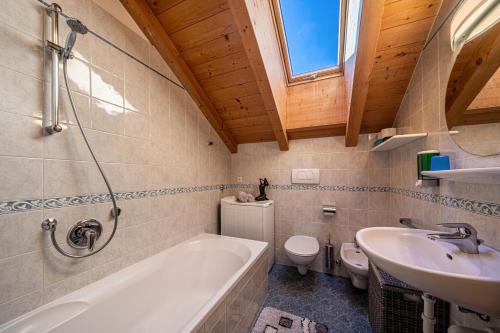 a bathroom with a tub and a sink and a toilet at Stücklhof Wohnung Edelweiss in San Genesio Atesino