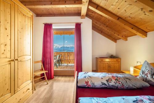 a bedroom with a bed and a large window at Stücklhof Wohnung Edelweiss in San Genesio Atesino