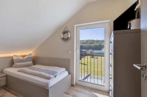 a room with a bed and a large window at Ferienanlage am Seerand in Joachimsthal