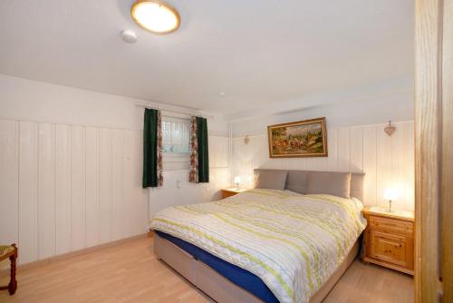 ein Schlafzimmer mit einem Bett, zwei Tischen und einer Lampe in der Unterkunft Obermaiselstein in Obermaiselstein