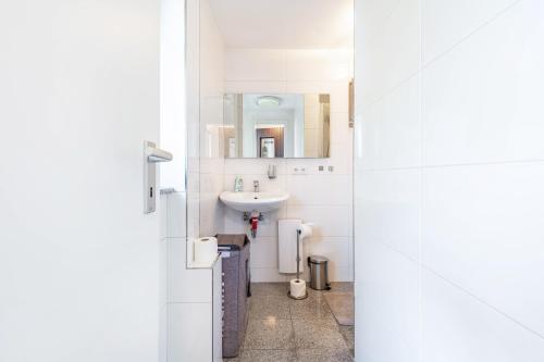 a white bathroom with a sink and a mirror at Ferien- Monteurwohnung in Nürnberg in Nuremberg