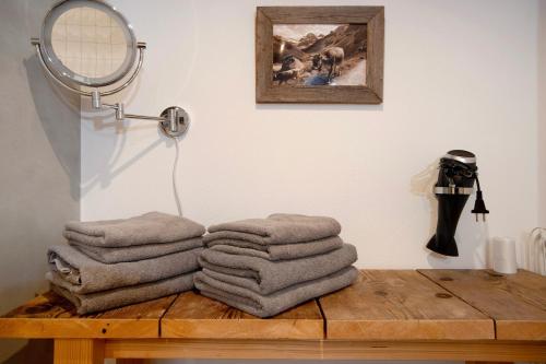 a pile of towels on a wooden table with a mirror at Alpenchalet Pfronten in Pfronten