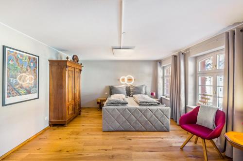 a bedroom with a bed and a red chair at Gästehaus Siebter Himmel in Burkheim