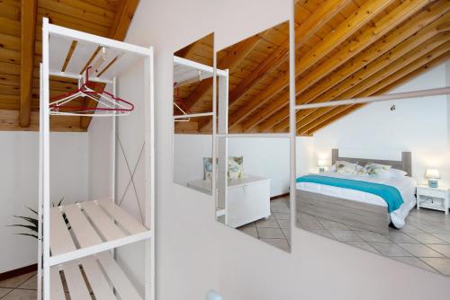 a bedroom with white walls and a bed with blue sheets at Vista da Baía - Casa do Aniceto in Almas