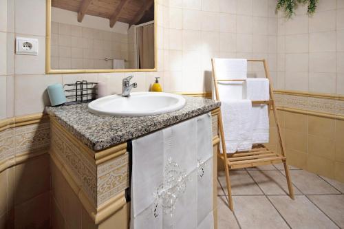 a bathroom with a sink and a chair at Vista da Baía - Casa do Aniceto in Almas