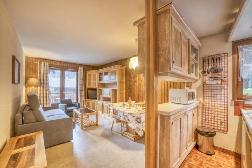 a kitchen and living room with a couch and a table at Studio cabine Le Charvet in Le Grand-Bornand