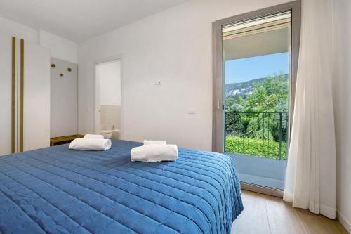 a bedroom with a blue bed and a large window at Residence Eleonora in Garda