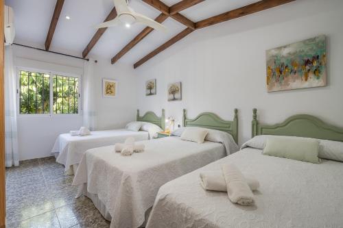 three beds in a room with white walls at El Amanecer in Motril