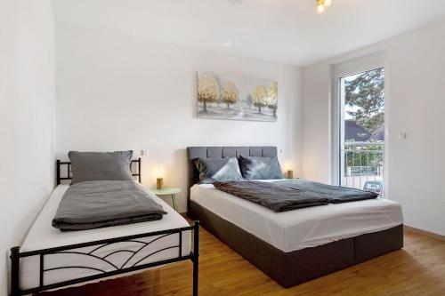 a bedroom with two beds and a window at White House Apartments in Kappel-Grafenhausen