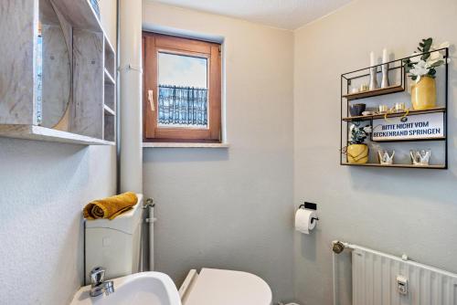 a bathroom with a toilet and a sink and a window at Ferienwohnung Zu Hause auf Zeit in Balingen