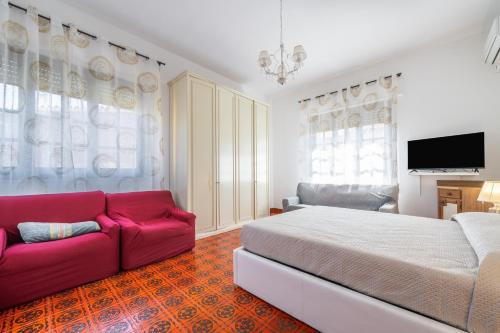 a bedroom with a large bed and a red couch at Il Faro in Sarroch