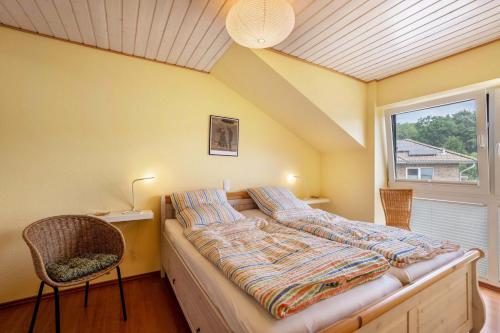 a bedroom with a bed and a chair and a window at Ferienwohnung 'Sonneck' in Eckernförde