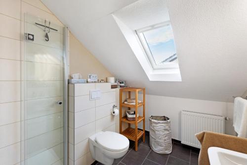 a bathroom with a toilet and a skylight at Ferienwohnung Obrighoven in Wesel