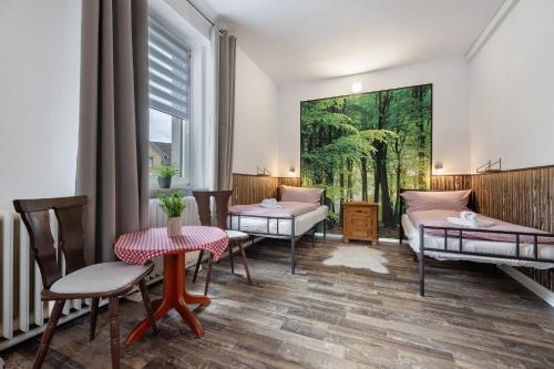a living room with two beds and a painting on the wall at Gruppenhaus Osterhagen in Bad Lauterberg