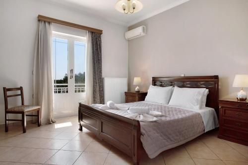 a bedroom with a large bed and a window at Christine's House in Zakynthos