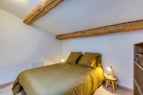 a bedroom with a green bed in a white room at Le Voltaire pour 4 in Sète