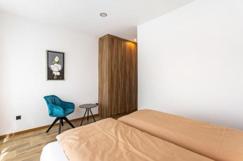 a bedroom with a bed and a chair and a cabinet at Ferienwohnung Sophie Stecker in Schmallenberg