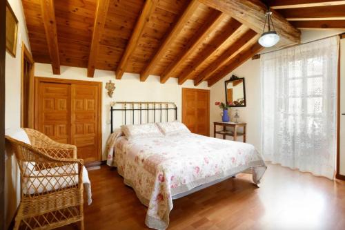 a bedroom with a bed and a wooden ceiling at El Molino del pepe in Almajano
