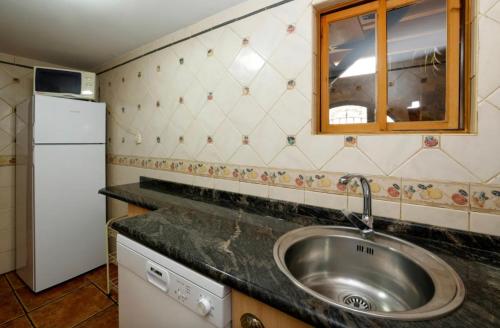 a kitchen with a sink and a white refrigerator at El Molino del pepe in Almajano
