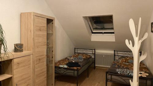 a small room with two beds and a window at Appartment nahe Galopprennbahn in Iffezheim
