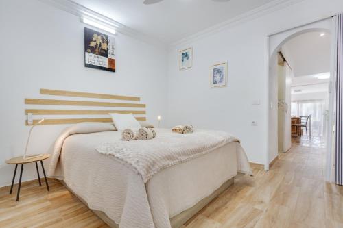 a white bedroom with a large bed and a table at Casa Lotti With Ocean View in Santa Cruz de Tenerife